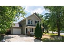 Charming two-story home with a well-manicured lawn, attached garage, and inviting front porch at 8343 Highlander Ct, Charlotte, NC 28269