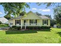 Charming single-story home featuring a welcoming front porch and well-manicured lawn at 8529 Indian Summer Trl, Harrisburg, NC 28075