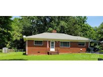 Charming brick home featuring a well-manicured lawn and inviting front entrance at 1512 Thompson Ave, Charlotte, NC 28216
