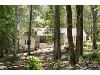 Secluded two-story home with a stone-accented front and gray painted siding nestled amongst mature trees at 1711 Apple Tree Ln # 28, Fort Mill, SC 29715