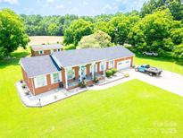 Charming red brick ranch-style home with a well-manicured lawn and a detached garage at 24132 Nc Hwy 73 Hwy, Albemarle, NC 28001