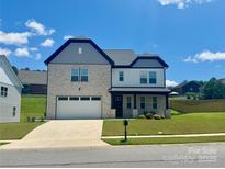 Charming two-story home with a brick and siding exterior, attached garage, and well-maintained lawn at 305 Pleasant Hill Se Dr, Concord, NC 28025