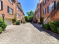 Charming brick townhomes feature a well maintained courtyard and garages with plenty of curb appeal at 344 S Laurel Ave, Charlotte, NC 28207