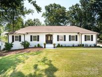 Charming white brick home with well-manicured lawn, dark shutters, and inviting front entrance at 6745 Lancer Dr, Charlotte, NC 28226