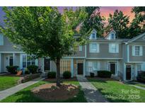 Charming townhome exterior with manicured lawn, mature tree, and sidewalks at 7518 Silver Arrow Dr, Charlotte, NC 28273