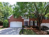 Charming two-story brick home featuring an attached two car garage and mature landscaping at 7554 Bluestar Ln, Charlotte, NC 28226