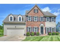 Charming brick and siding two-story home featuring a well-manicured lawn and a two-car garage at 8417 Hirsch Dr, Charlotte, NC 28277