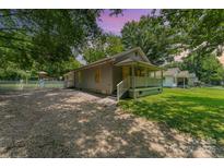 Charming home featuring a welcoming front porch and a spacious, gravel driveway at 909 Lakeview St, Kannapolis, NC 28083