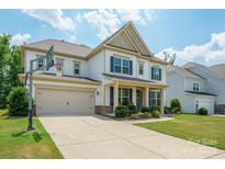 Charming two-story home with a well-manicured lawn and a basketball hoop over the garage at 10437 Paper Birch Dr, Charlotte, NC 28215