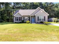 Charming single-story home featuring a well-manicured lawn and a welcoming blue front door at 117 Franklin St, Clover, SC 29710
