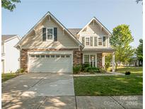 Charming two-story home with a two-car garage, stone accents, and landscaped front yard at 1304 Hammond Dr, Matthews, NC 28104