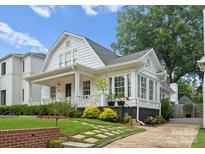 Charming home featuring a welcoming front porch, manicured landscaping, and classic architectural details at 2015 Lombardy Cir, Charlotte, NC 28203
