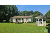 Charming single-story home featuring a covered porch, well-manicured lawn, and a quaint gazebo at 233 Hicks Rd, Statesville, NC 28625