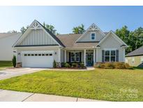 Charming single-Gathering home with a manicured lawn, inviting entrance, and attached two car garage at 2407 Baxter Se Pl, Concord, NC 28025