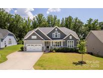 Charming gray home featuring a two-car garage, manicured lawn, and classic architectural details at 252 Broadleaf Dr, Denver, NC 28037