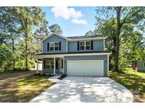 Charming two-story home featuring a covered front porch, attached garage, and well-maintained lawn at 411 Patience Dr, Concord, NC 28025