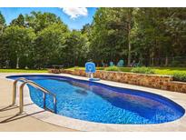 Beautiful in-ground pool with basketball hoop and lounging area surrounded by lush landscaping at 5105 Paisano Ln, Waxhaw, NC 28173