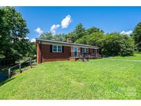 Charming brick home with lush green lawn and black shuttered windows at 559 15Th Se Ave, Hickory, NC 28602