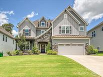 Charming two-story home with stone accents, a well-manicured lawn and a two car garage at 7009 Providence W Ln, Charlotte, NC 28226