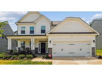Charming two-story home with white siding, stone accents, and a two-car garage in a well-manicured neighborhood at 154 Cotton Field Dr, Statesville, NC 28677