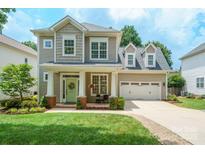 Charming two-story home with inviting front porch, well-manicured lawn and attached two-car garage at 20444 Greenway Heights Dr, Cornelius, NC 28031