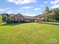 Lovely brick home with well-manicured lawn and extended covered parking area at 3206 Basilwood Cir, Monroe, NC 28110