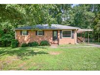 Charming single-story brick home with black shutters, a pergola, and a well-maintained lawn at 408 Kennerly Dr, Indian Trail, NC 28079
