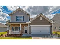Charming two-story home showcasing a well-manicured lawn and an inviting front porch at 513 Jacobus Ln, Monroe, NC 28112