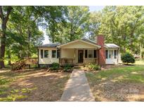Charming single-story home with inviting front porch, brick chimney, and walkway, surrounded by mature trees at 6115 Campbell Rd, York, SC 29745