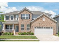 Charming two-story brick home with a manicured lawn and attached two-car garage at 6320 Tilley Way, Matthews, NC 28105