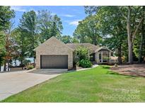 Charming brick home with a two-car garage, green lawn, and beautiful landscaping at 849 Kemp Rd, Mooresville, NC 28117
