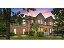 Charming two-story brick home with a welcoming front porch and manicured landscaping at 125 Snow Fountain Ln, Mooresville, NC 28115