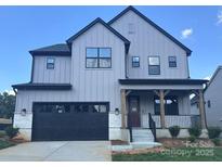 Beautiful new construction home with gray siding, black trim, a front porch, and a two-car garage at 15012 Brownleigh Ln # 30, Huntersville, NC 28078
