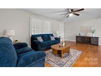 Cozy living room featuring a blue sofa, hardwood floors, and a ceiling fan at 151 Third Creek Rd, Statesville, NC 28677