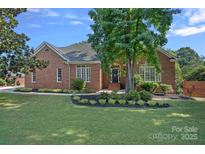 Charming, single-story red brick home with a manicured lawn and mature landscaping at 343 Gringley Hill Rd, Fort Mill, SC 29708