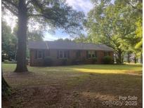 Charming single-story home with brick facade nestled among mature trees and a spacious front yard at 4050 Rollingwood Cir, Rock Hill, SC 29732