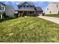 Traditional two-story home featuring manicured lawn, brick facade, covered porch and attached garage at 5013 Crandon Rd, Fort Mill, SC 29707