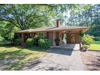 Charming brick home with a covered entryway, mature landscaping, and a long driveway at 5329 E Highway 27 Hwy, Iron Station, NC 28080