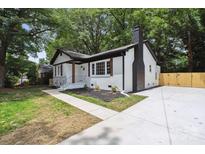 Charming exterior of a painted brick home with modern black and white trim and a lush landscaped front yard at 5420 Gwynne Ave # 21, Charlotte, NC 28205