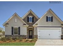 Charming home featuring stone accents, complementary siding, and a two-car garage at 5950 Oak Branch Cir, Maiden, NC 28650
