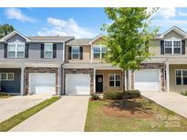 Charming townhome exterior showcasing a well-maintained lawn, attached garages, and colorful siding under a bright sky at 6507 Revolutionary Trl, Charlotte, NC 28217