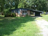 Charming single-story home featuring a brick facade, covered parking, and a spacious front yard at 761 Henry Rhodes Rd, Lincolnton, NC 28092