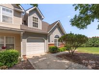 Charming townhome with a one-car garage, complemented by manicured landscaping and a welcoming facade at 825 Rock Lake Gln, Fort Mill, SC 29715