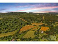 Stunning aerial view of a sprawling property with rolling hills, lush greenery, and clear blue skies at 1043 Linneys Mill Rd, Union Grove, NC 28689