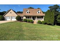 Charming brick home featuring a manicured lawn, two car garage, and a cozy front porch at 1335 33Rd Avenue Ne Dr, Hickory, NC 28601