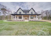 Stunning two-story home with a covered front porch, beautiful landscaping, and a freshly sodded yard at 4023 Yesteryears Ln, Marshville, NC 28103