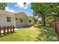 Inviting home exterior featuring a lush backyard, a covered patio, and mature trees at 6208 Karenstone Dr, Charlotte, NC 28215