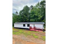 Charming mobile home features a metal roof, white siding, and a red-painted ramp and porch at 6517 Helens Way, Denver, NC 28037