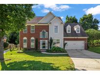 Charming brick and siding home featuring a well-manicured lawn and two-car garage at 8000 Pelorus Ln, Charlotte, NC 28269
