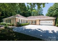 Charming single-story home with brick and stone accents, mature trees, and an expansive driveway at 804 Creek Bluff Rd, Rock Hill, SC 29732